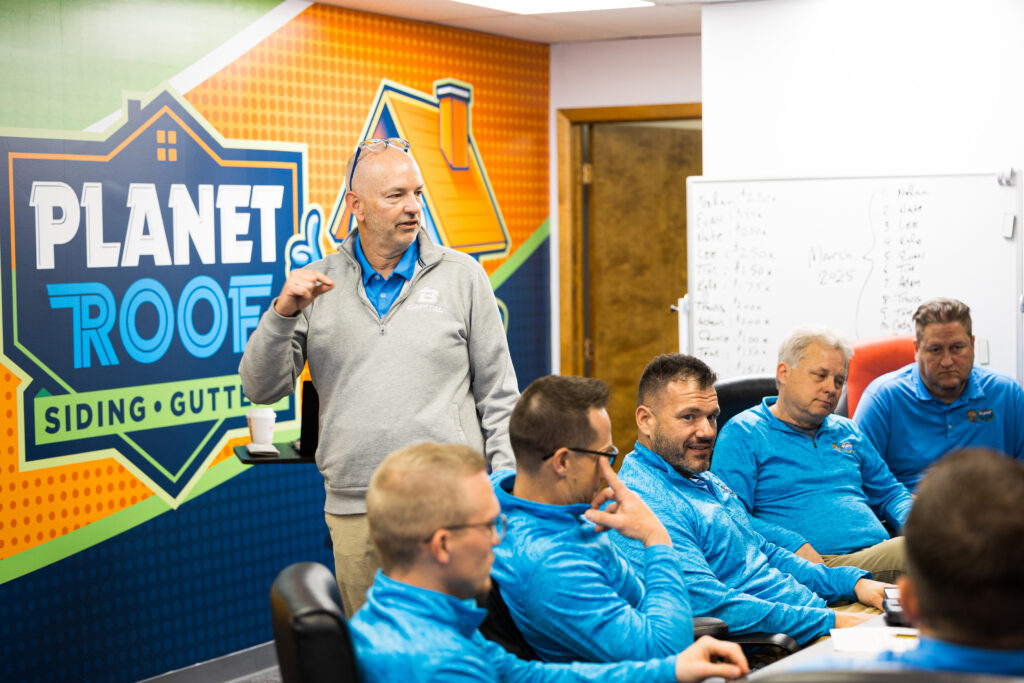 Planet Roof team members seated in a conference room during a business and operations meeting.