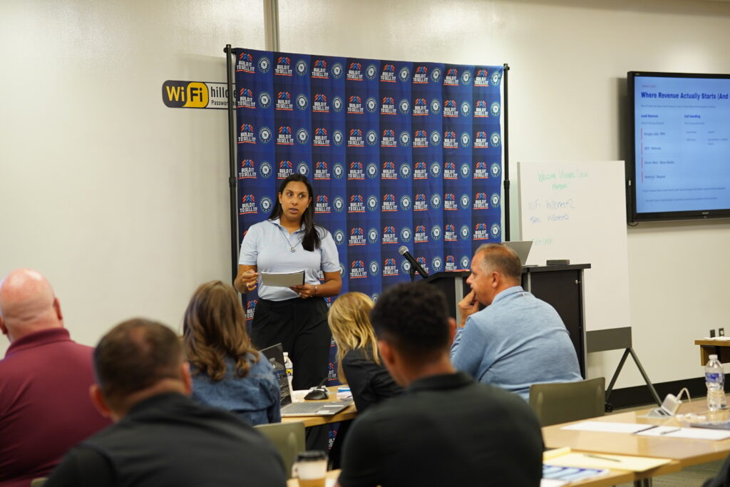 Female executive presenting a lead intake and call handling workflow strategy next to a digital display monitor outlining marketing channels for business owners.