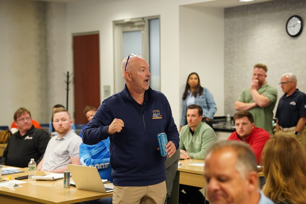 Corporate business strategist holding an aluminum can and raising his fist while passionately answering audience questions during an advanced operations training seminar.