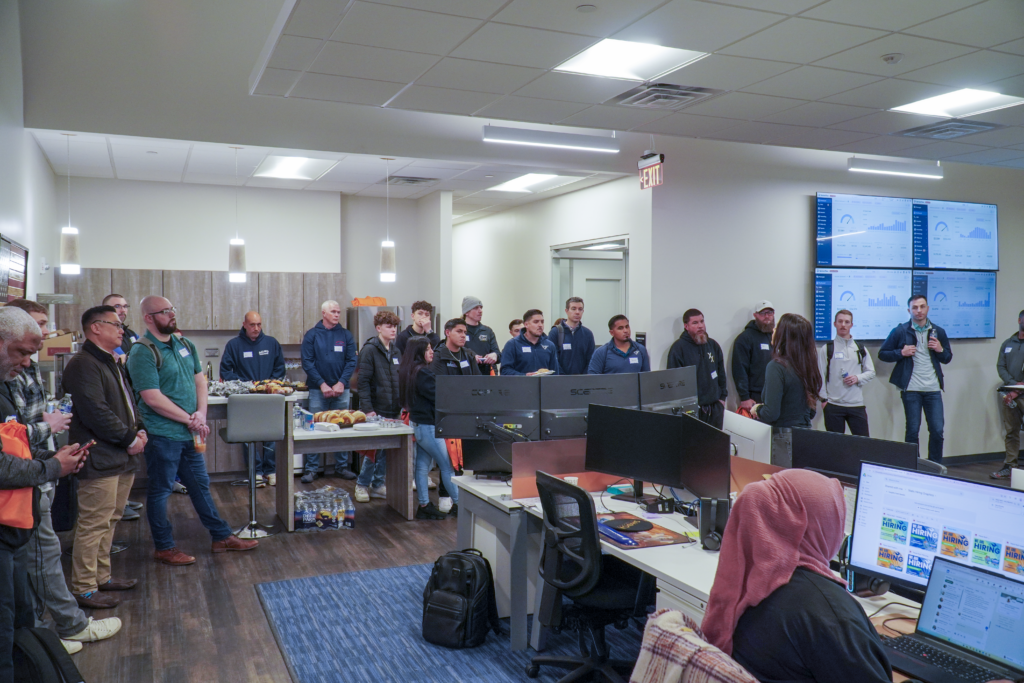 Build It To Sell It shop tour attendees gathered inside a home services office during an operations walkthrough.