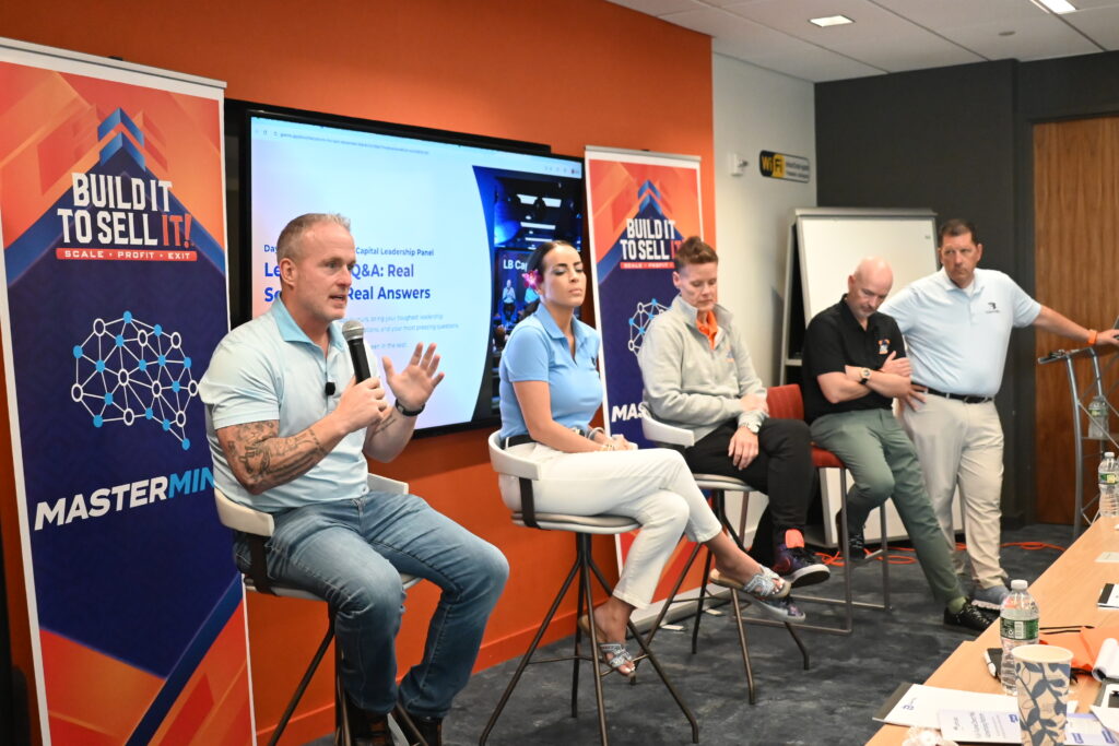 Lance Bachmann, Kelly Mesaris, Jolin Bachmann, Mike Shelly, and Bill Rosell speaking on a Build It To Sell It Mastermind panel.